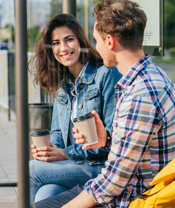 English School in London and Worldwide two young students talking at a bus stop with coffee