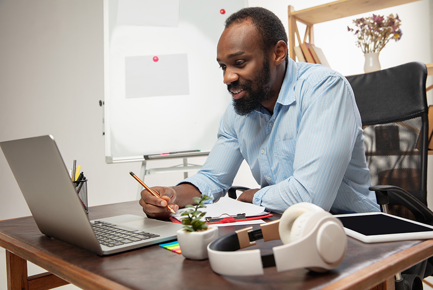 English School in London and Worldwide man using laptop at home to learn English